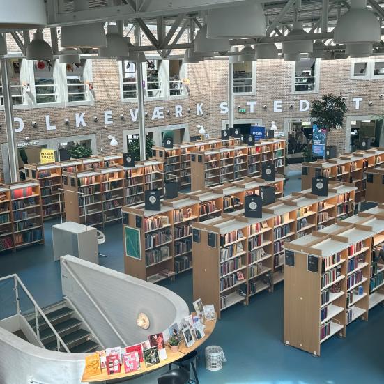 Udsigt oppe fra over Hovedbibliotekets rum. I baggrunden ses "FOLKEVÆRKSTEDET" på væggen.