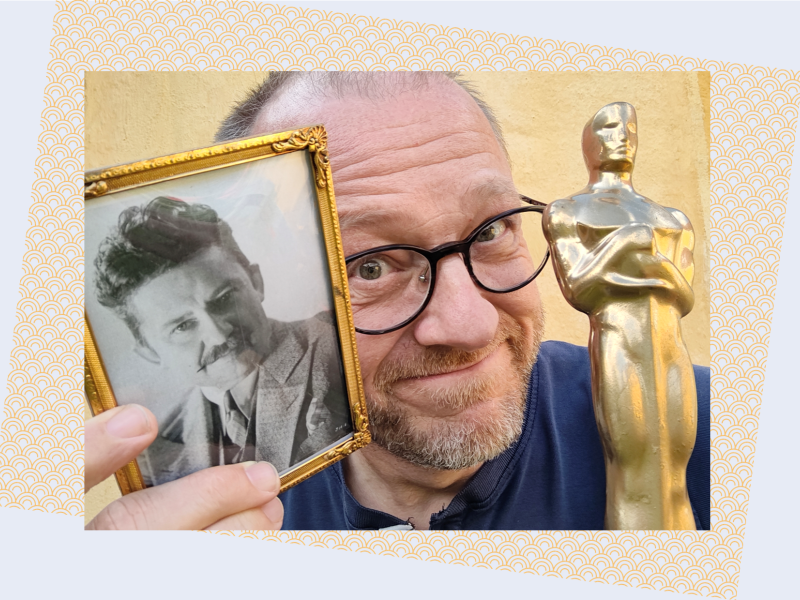 Hans Wendelboe Bøcher står med et foto af Jean Hersholt og en Oscar-statuette