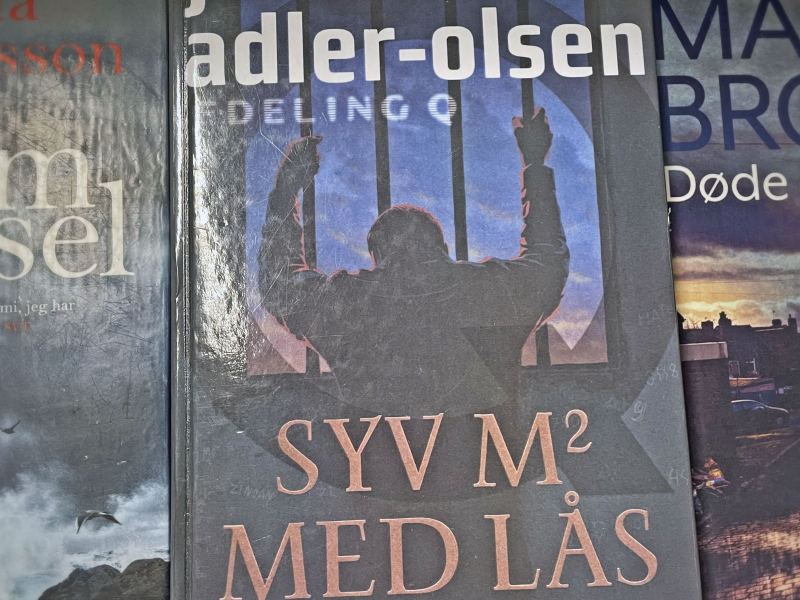 Syv m2 med lås ligger oven på en stak med bøger