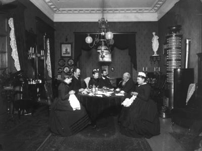 En familie sidder omkring et bord på et ældre sort hvid foto